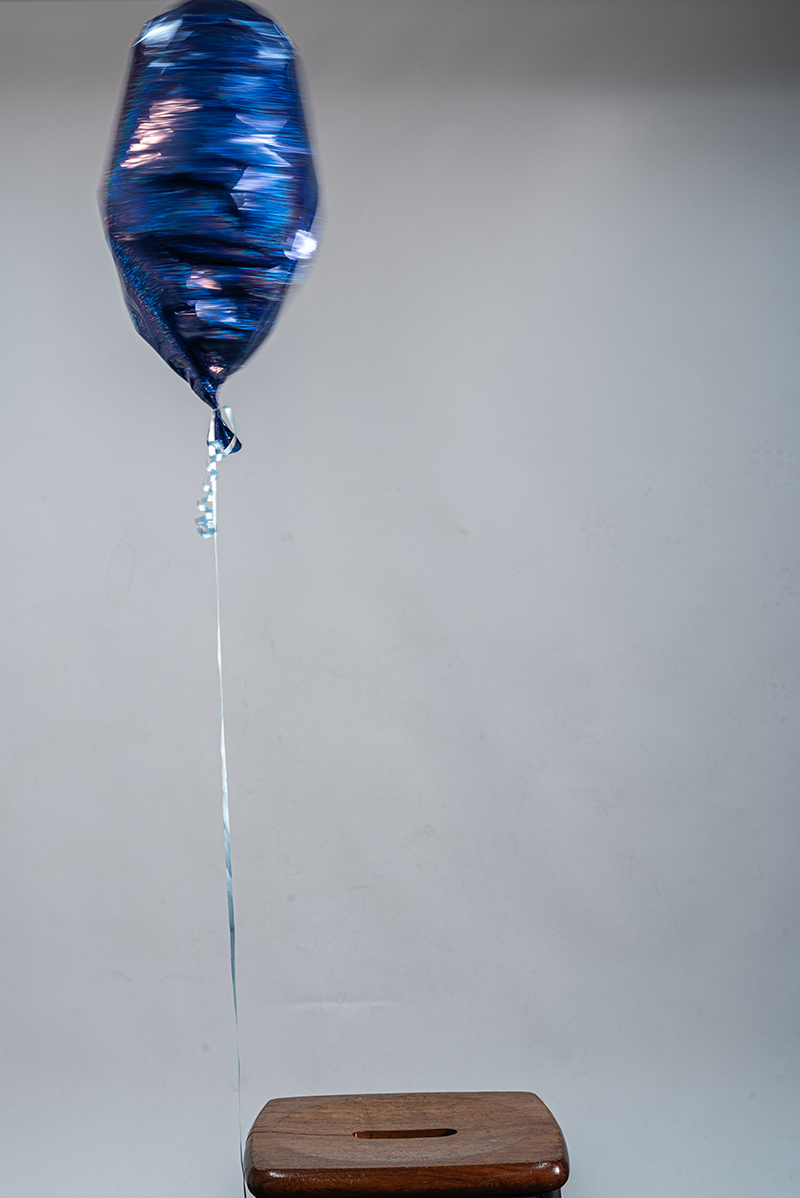 The chair waits, empty. The balloon remembers