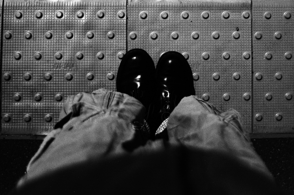 Boots, railway platform, black and white, 2023, Nikon F100 Ferrania P30